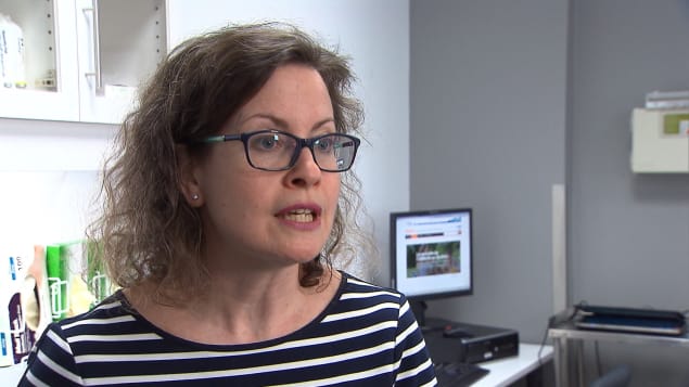 MÃ©lanie Henderson porte des lunettes et accorde une entrevue dans son bureau.