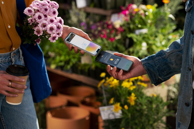 A customer uses Tay to Pay on iPhone to purchase produce at the farmer’s market.