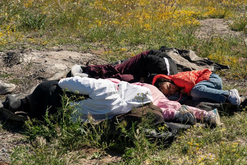 一群中国走线客因太过疲劳睡在草地上。(路透)