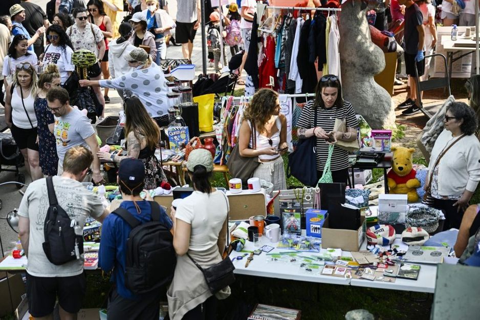 购物者在2023年5月27日于渥太华的伟大格里布车库拍卖会上查看摆放的商品。 THE CANADIAN PRESS/Justin Tang